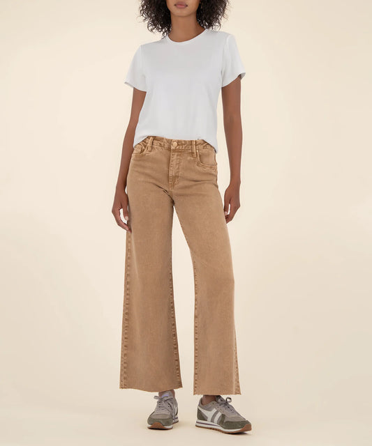 Person wearing a white t-shirt and tan wide-leg jeans on a beige background